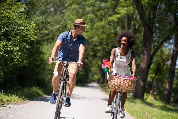 Joven pareja multiétnica teniendo un paseo en bicicleta en la naturaleza
 - Foto, imagen