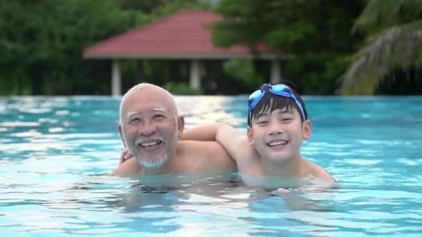 プール、アジア人の孫、祖父母のプールで水泳で遊んで幸せのアジア家族のスローモーション. - 映像、動画