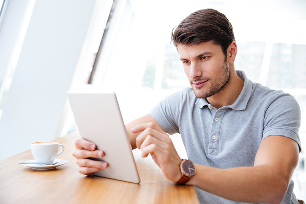 Young businessman in casual clothes using tablet indoors - Foto, imagen