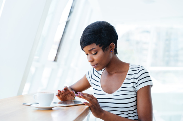 Pretty african businesswoman using tablet amd having coffee break - Photo, Image