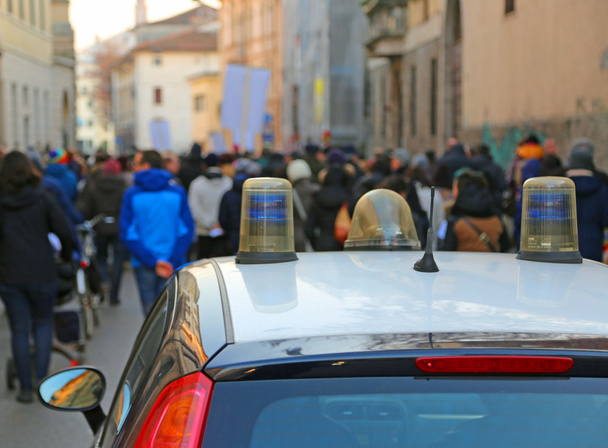Poliisiauto saattoi mielenosoittajia katumielenosoituksen aikana.
 - Valokuva, kuva