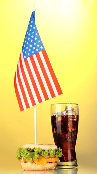 tasty sandwich and cola with american flag, on yellow background - Фото, изображение
