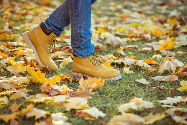 Warme gele laarzen. Wandelen in de herfst bladeren - Foto, afbeelding