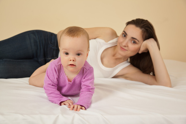 Mother with baby lying on bed - Photo, Image