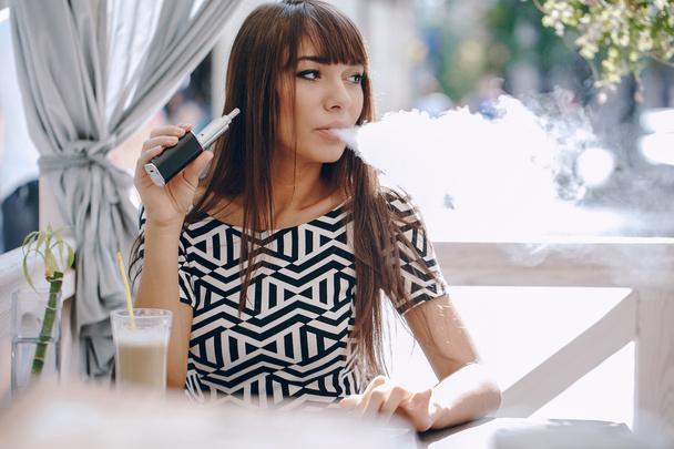 girn in cafe with E-Cigarette - Foto, immagini