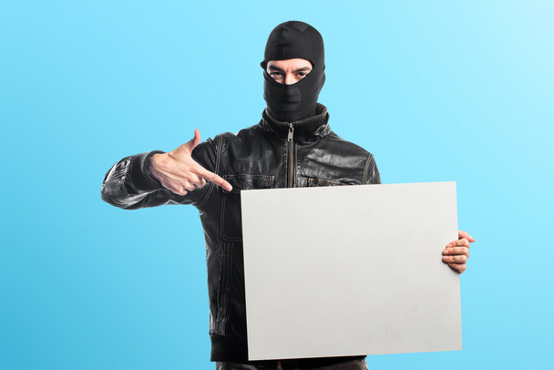 Ladrón sosteniendo un cartel vacío
 - Foto, imagen