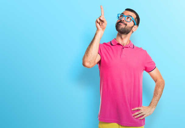 Man with colorful clothes pointing up - Photo, Image