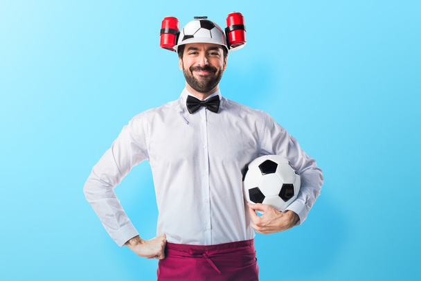 Camarero loco sosteniendo una pelota de fútbol
 - Foto, imagen