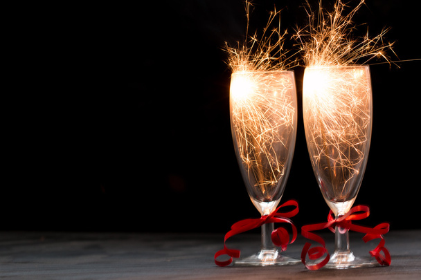 Glasses of champagne and sparklers on black background , merry christmas concept - Фото, зображення