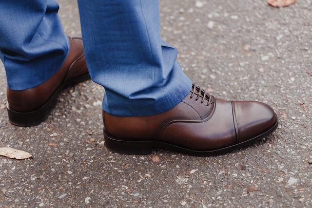 Feet man in brown shoes outdoors. - Fotoğraf, Görsel