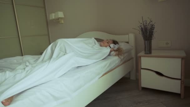 Fresh and happy woman in bed wakes up in the morning smiling - Materiał filmowy, wideo