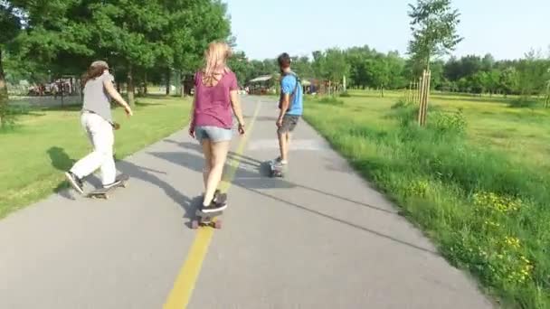friends skateboarding on sunny day - Materiał filmowy, wideo