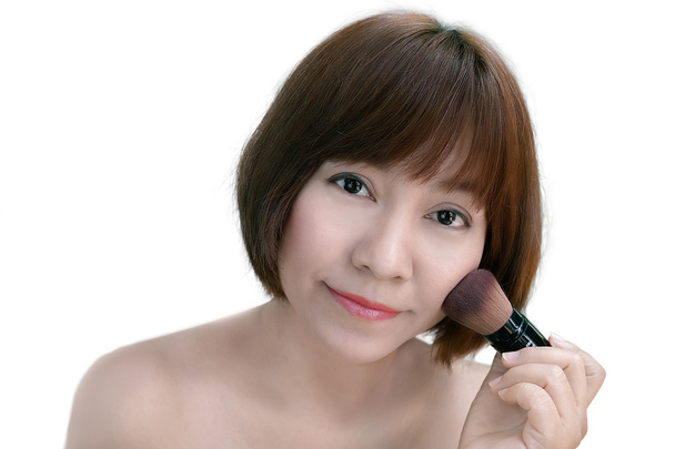 Aziatische vrouw met kort haar toepassing van make-up - Foto, afbeelding