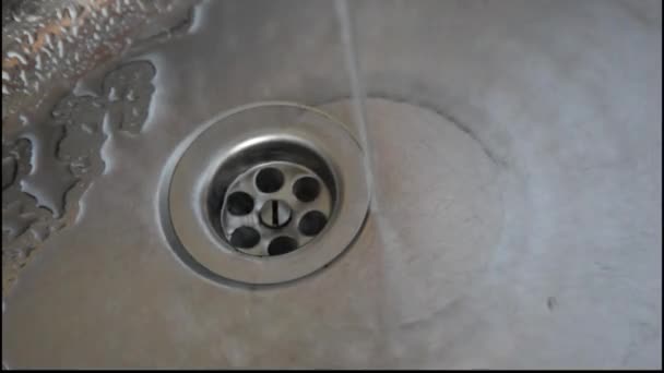 Wasser aus einem aufgedrehten Wasserhahn fließt in einer Küchenspüle. - Filmmaterial, Video