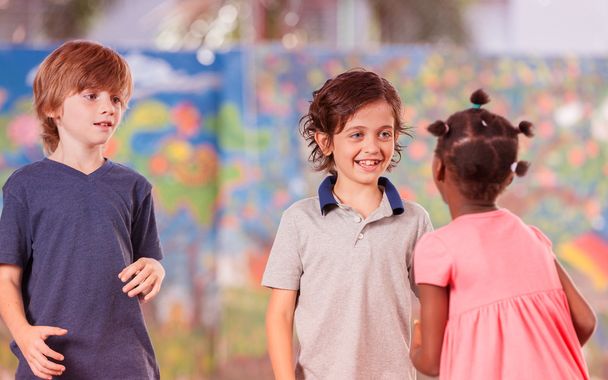 Mixed race classmates playing in schoolyard - Photo, Image