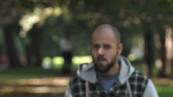 man walking in the park sees something that upsets him - Materiaali, video
