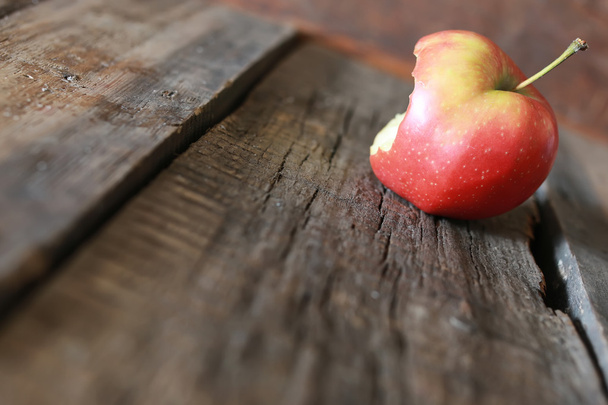 bitten apple on a wooden background - Photo, Image