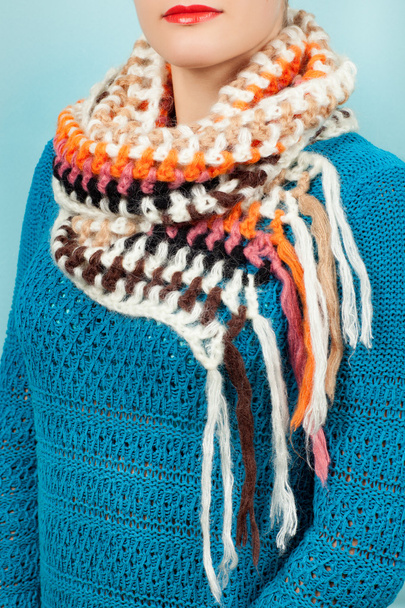 Woolen scarf. Beige woolen scarf around her neck isolated on blue background. - Fotó, kép