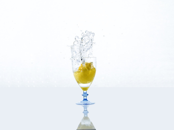 water splashing from glass with lemon, its on white background. - Fotografie, Obrázek