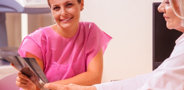 Happy female patient looking at hospital test results - Photo, Image