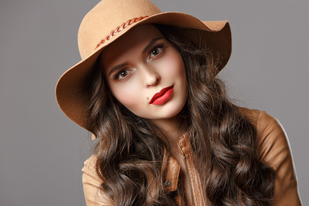 Sexy beautiful girl with shiny hair and a hat with red lips, clo - Fotó, kép
