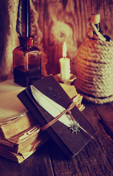 ρετρό αντικείμενα φτερό και leaher βιβλίο με φως των κεριών - Φωτογραφία, εικόνα