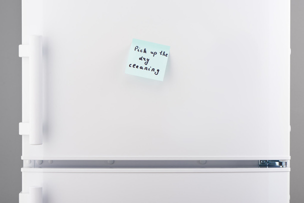 Pick up lavaggio a secco su carta da lettere blu sul frigorifero bianco
  - Foto, immagini