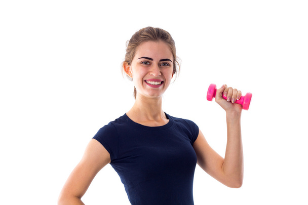 Woman holding a pink dumbbell - Foto, afbeelding