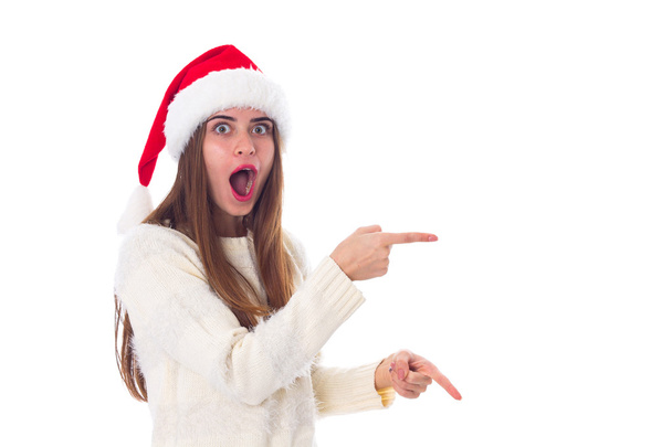 Woman in red christmas hat pointing on something - Foto, Bild