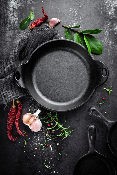 cast iron pan and spices on black metal culinary background - Fotoğraf, Görsel