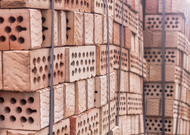 Una pila de ladrillos de arcilla roja con agujeros
 - Foto, Imagen