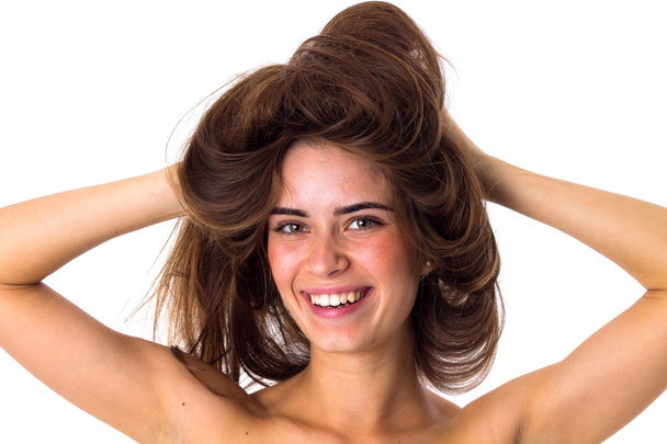 Mujer sonriente sosteniendo su cabello enredado
 - Foto, Imagen