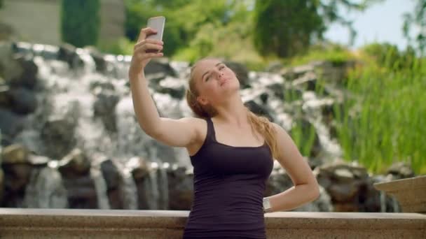 Nuori nainen ottaa selfien puistossa. Selfie-nainen. Nainen selfie
 - Materiaali, video