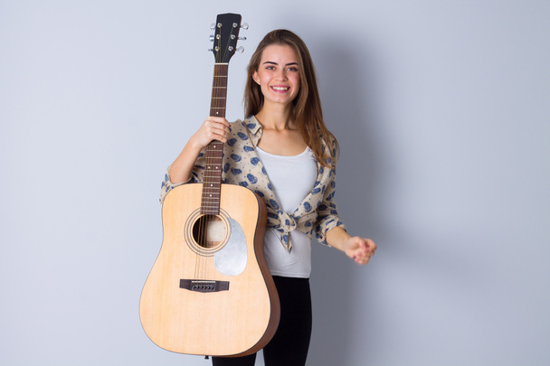 Mujer joven sosteniendo una guitarra
 - Foto, Imagen