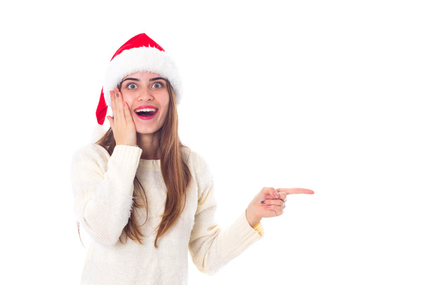 Woman in red christmas hat pointing on something - Foto, imagen