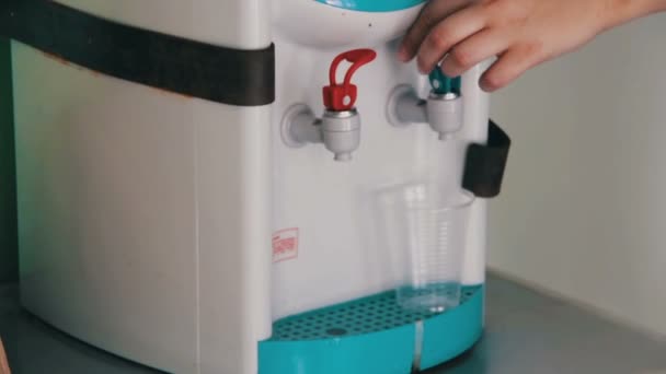 Napełniania cup w chłodnicy wody, dozownik wody - Materiał filmowy, wideo