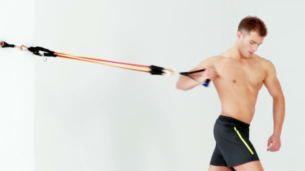 schöner muskulöser Mann, der mit Gummi auf weißem Untergrund trainiert - Filmmaterial, Video