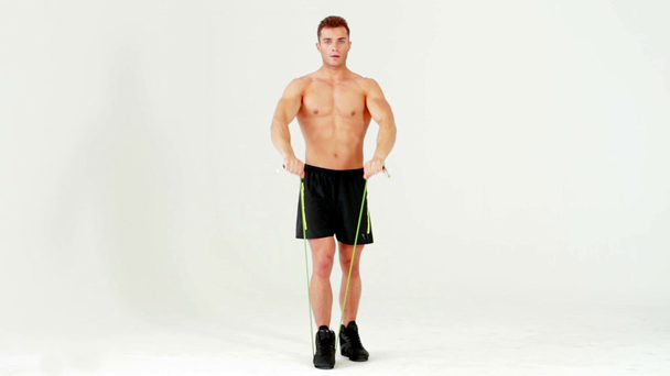 Hombre musculoso guapo haciendo ejercicio con goma sobre blanco
 - Imágenes, Vídeo