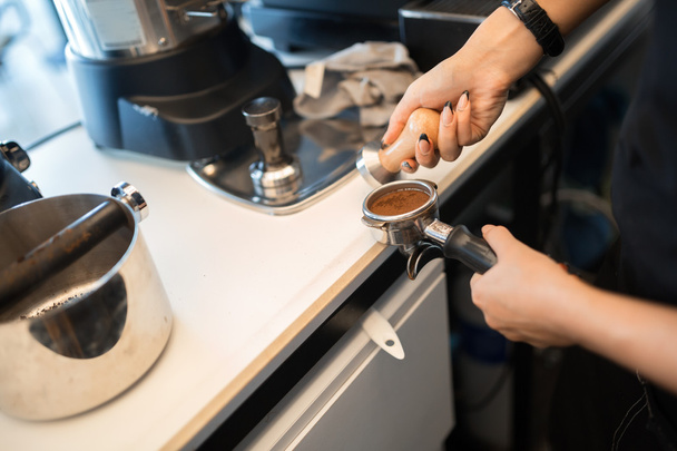 Barista tampering coffee - Фото, изображение