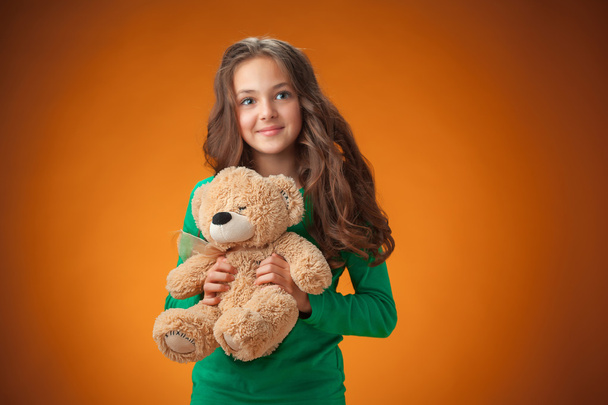 The cute cheerful little girl on orange background - Fotoğraf, Görsel