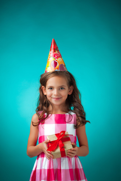 The cute cheerful little girl on blue background - 写真・画像