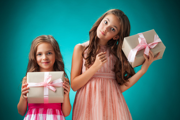 The two cute cheerful little girls on blue background - Foto, Imagem