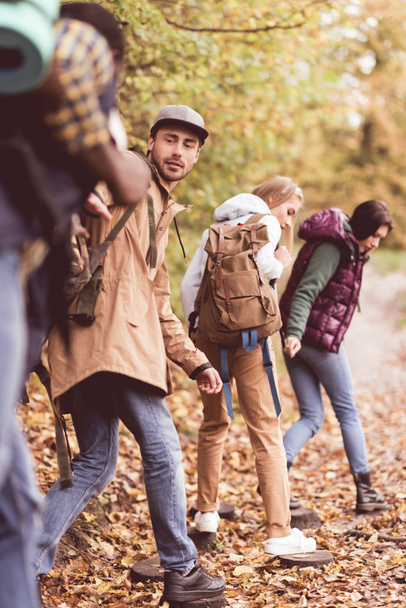 Friends backpackers in autumn forest - 写真・画像