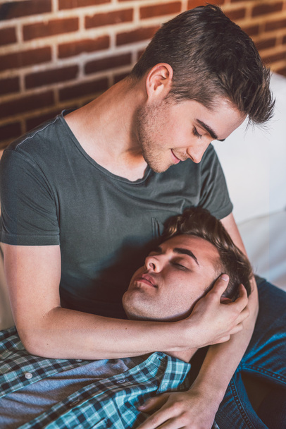 gay couple together on sofa at home - Foto, Imagen