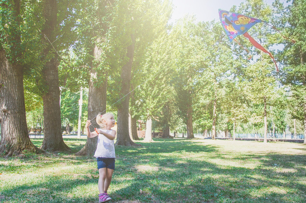 girl with flying kite - Foto, afbeelding