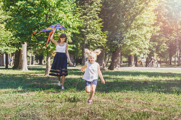 mother and daughter with flying kite - Photo, image