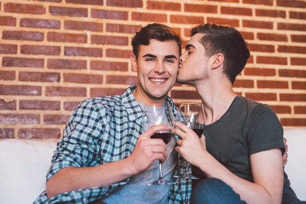 man kissing partner while drinking wine - 写真・画像