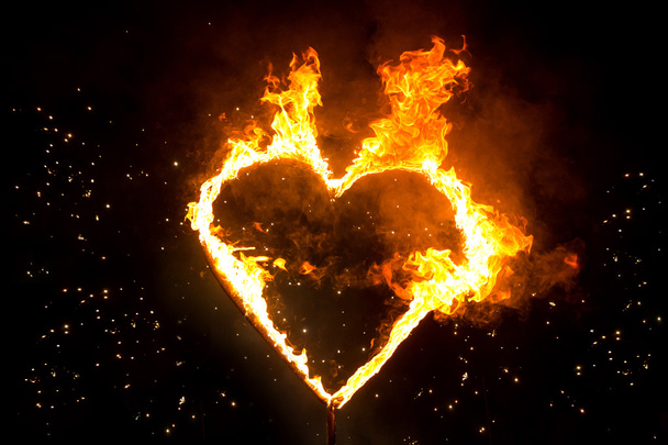 Fiery heart. Fire in the night. Heart on fire. Sparks from the f - 写真・画像