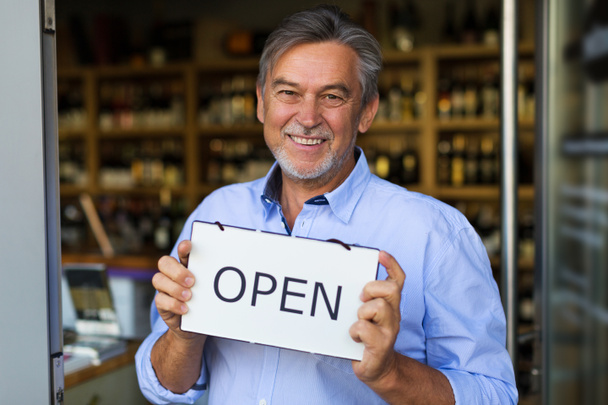 Wine shop owner holding open sign - Фото, изображение