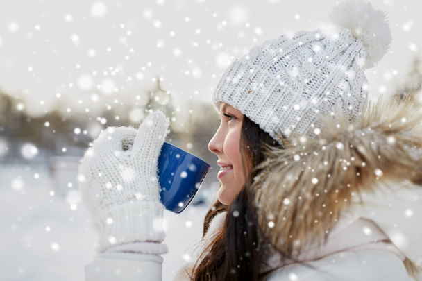 happy young woman with tea cup outdoors in winter - Foto, Bild
